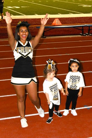 Alyanna Myrick, junior, stands with children in a cheer clinic Topeka High's cheer and dance team had throughout the week.
