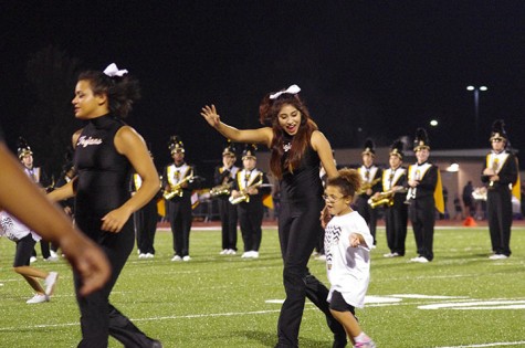 Shalma Reyes, Senior dancer, dances with a kid off the field after the half time performance 