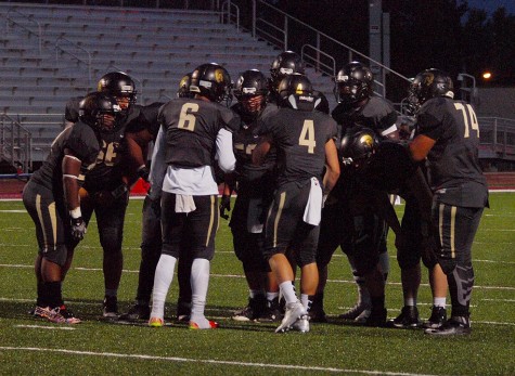 Topeka High's offensive power package huddles near the goal line before punching in a score by senior Dante Brooks at the end of the first half.