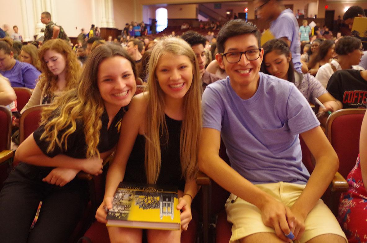 Jessica Moore, Stevi Lorson, and Jaime Ramirez, seniors, smile with this year's yearbook. Photo by Erin Mumford.