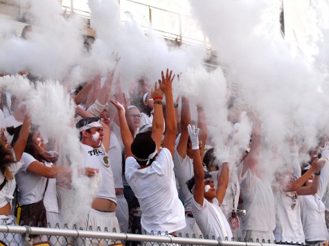 The Topeka High student section, whose dress theme was "White Out," throws masses of baby powder into the air at kickoff.