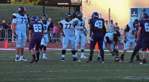 The Trojan offensive line calling out blocking assignments before a play.