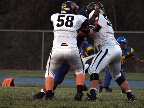 Tanner Matthias, sophomore (58), and Ryan Luna, senior (56), blocking a Schlagle defender.