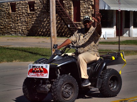 Divison principal Rodney Johnson riding a four wheeler up eighth street on the Homecoming parade route.