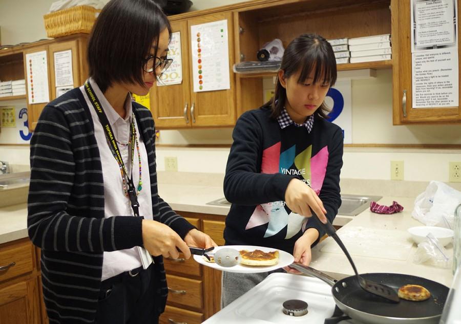 Vogel assisting an exchange student from Washburn make her pancake. 