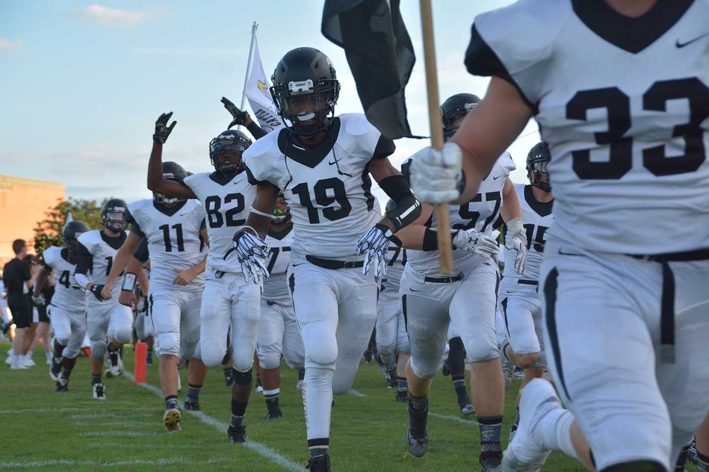 Joel Matlock (19), senior, smiles for the camera as he runs for the sideline before Friday Night's Topeka High-Hayden football game. Matlock was a part of a defense which allowed only 6 second half points against the Hayden Wildcats