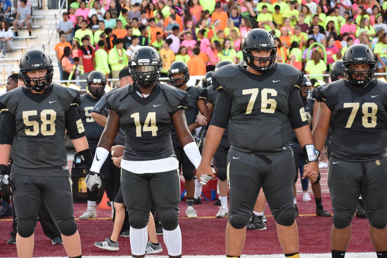 Seniors Tanner Matthias, Xavier Dunbar, Matthew Garza, and Tucker Richey hold hands in preparation to walk out on the field. (File Photo)