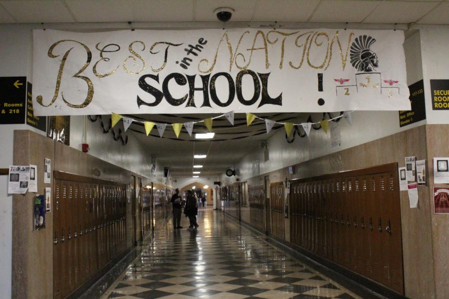 The banner hanging in the front hall that reads Best School in the Nation. The banner was created by senior stugo members as a contribution to the various hallway decorations put up by all four classes.
