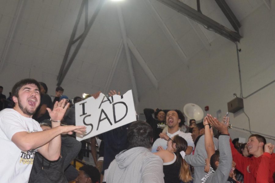 The sign in question being ripped apart in Topeka High's student section.