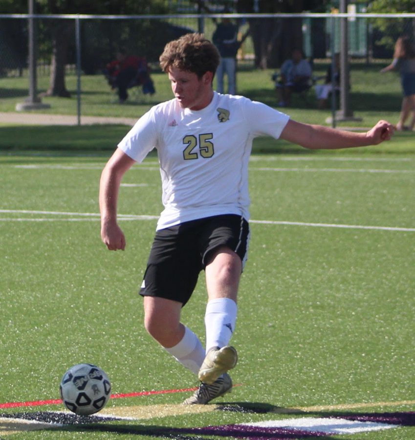 Isaiah Huckins passing the ball out of the defensive side of the field.