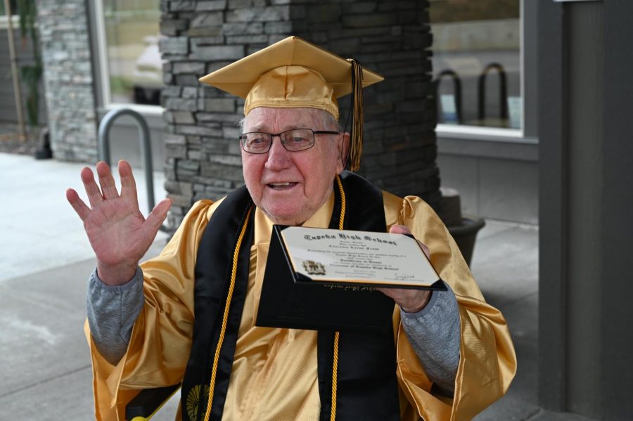 Clarence Frost holding his Topeka High School diploma after waiting 75 years
