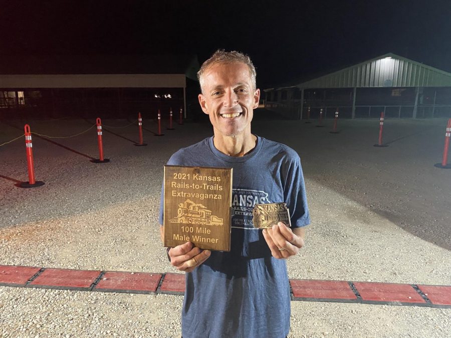 Hays holding the award that he won at the 100 mile marathon. 